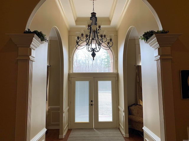 entrance foyer featuring ornate columns, french doors, a notable chandelier, and ornamental molding