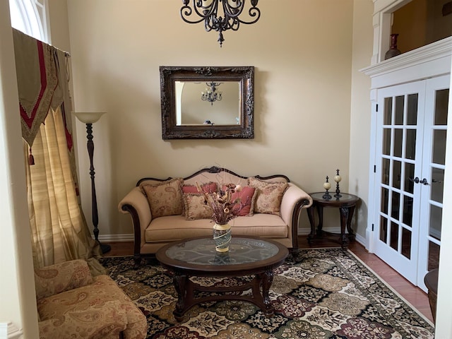 sitting room featuring hardwood / wood-style floors, french doors, and an inviting chandelier