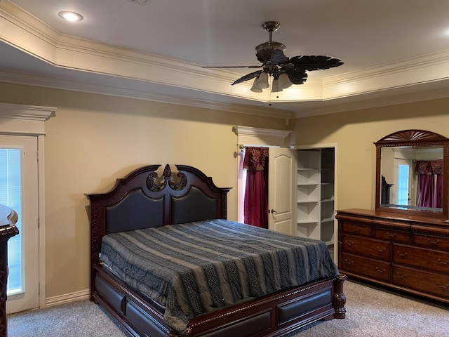 bedroom featuring light colored carpet, ceiling fan, and a tray ceiling