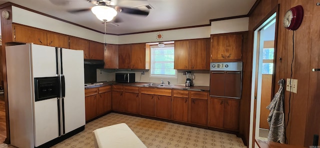 kitchen featuring crown molding, oven, white refrigerator with ice dispenser, and ceiling fan