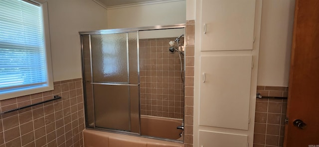 bathroom with combined bath / shower with glass door, tile walls, and crown molding