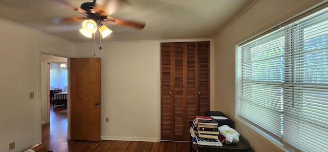 unfurnished bedroom featuring dark hardwood / wood-style flooring, ceiling fan, crown molding, and a closet