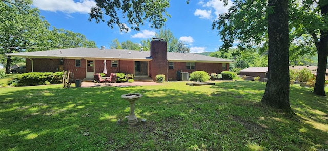 rear view of property featuring a patio area and a lawn