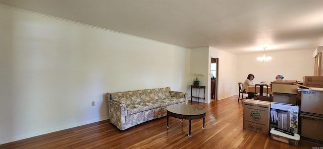 sitting room with hardwood / wood-style floors and an inviting chandelier