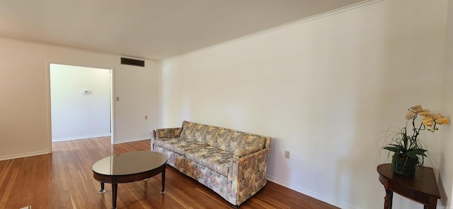 living area with wood-type flooring and crown molding