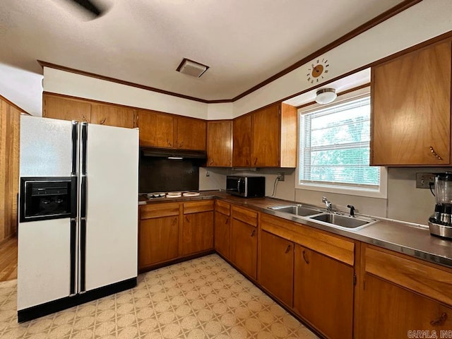 kitchen with white fridge with ice dispenser, ornamental molding, stovetop, light tile floors, and sink