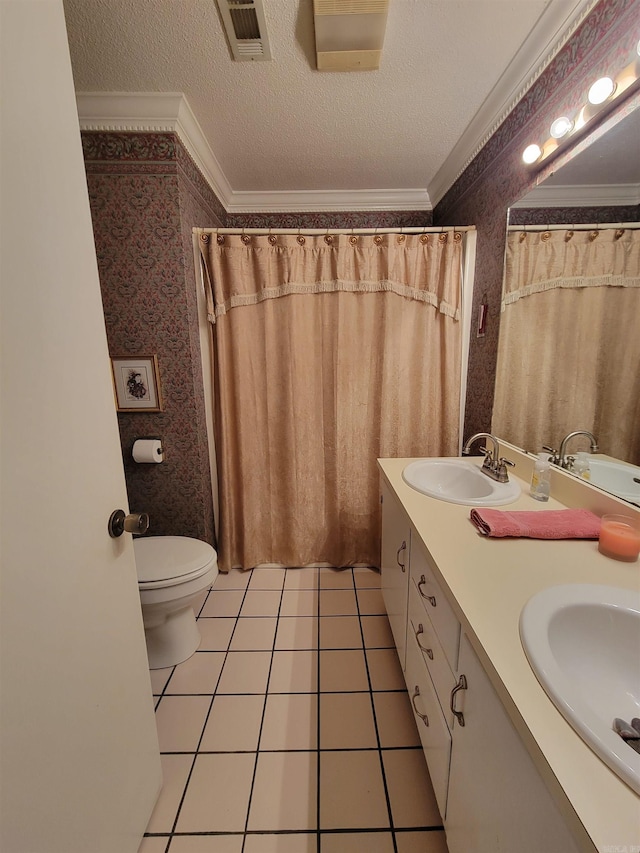 bathroom with a textured ceiling, vanity, tile patterned flooring, crown molding, and toilet