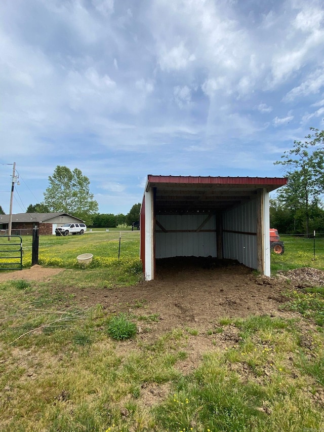 view of outdoor structure featuring a carport and a rural view