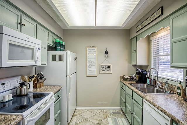 kitchen with light tile floors, green cabinetry, white appliances, and sink