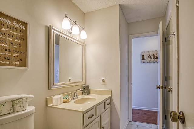 bathroom featuring wood-type flooring, a textured ceiling, vanity, and toilet