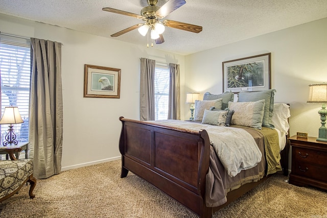 carpeted bedroom featuring ceiling fan and a textured ceiling