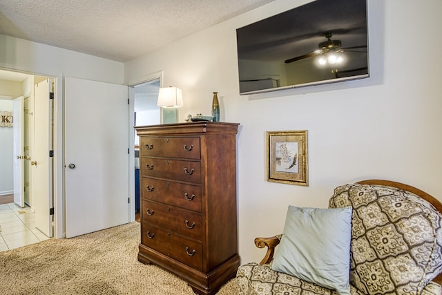 living area featuring light colored carpet, a textured ceiling, and ceiling fan