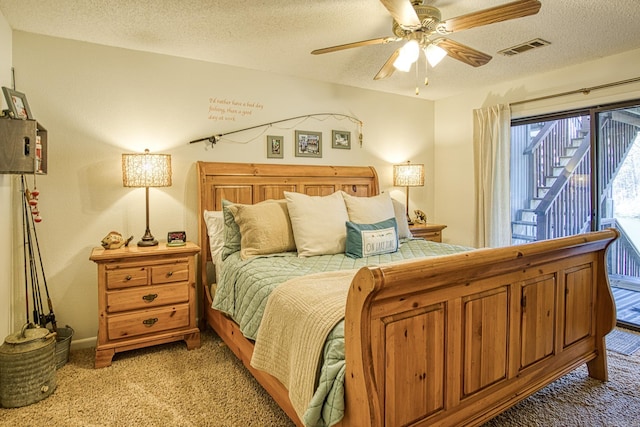 carpeted bedroom featuring a textured ceiling and ceiling fan