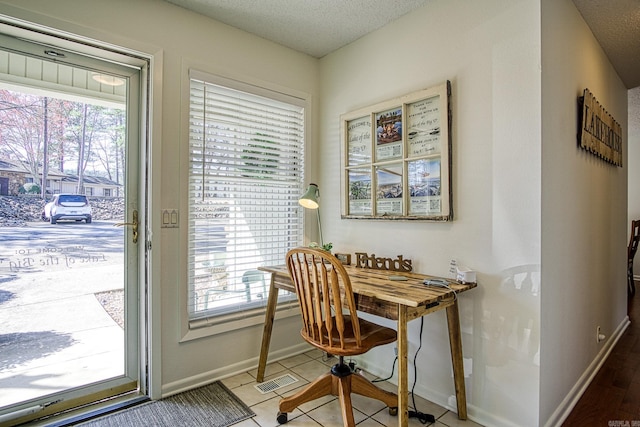 office space with tile floors and a textured ceiling