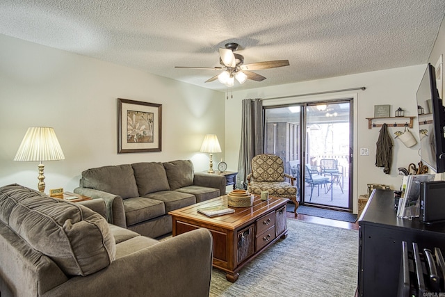 living room featuring ceiling fan and a textured ceiling