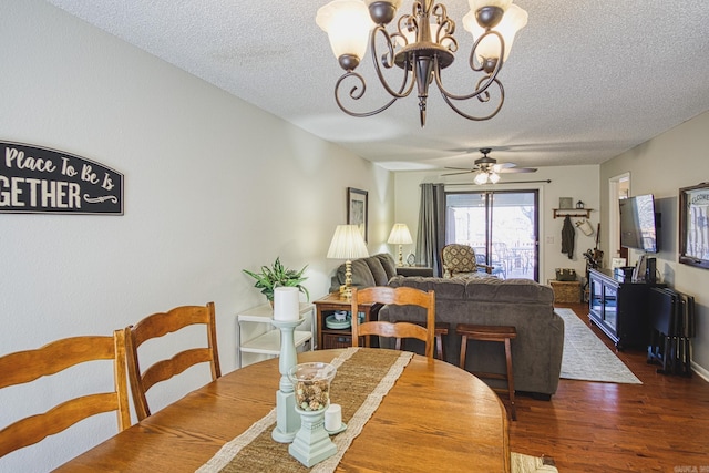 dining room featuring dark hardwood / wood-style flooring, ceiling fan with notable chandelier, and a textured ceiling