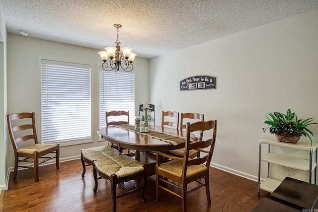 dining space featuring a textured ceiling, dark hardwood / wood-style flooring, and a chandelier