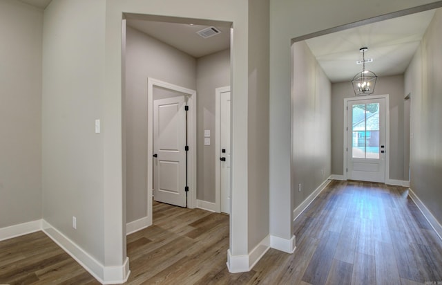 foyer with light hardwood / wood-style floors and a notable chandelier