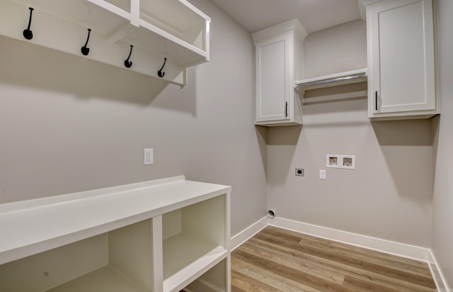 washroom featuring washer hookup, hookup for an electric dryer, cabinets, and light wood-type flooring