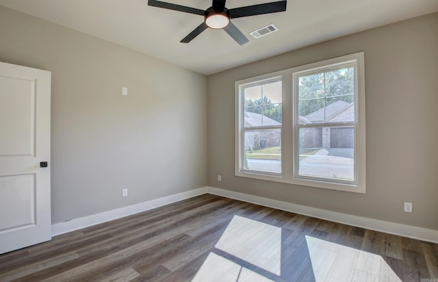 spare room with dark wood-type flooring and ceiling fan