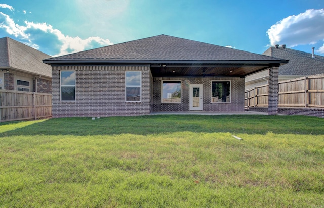 rear view of house featuring a lawn and a patio