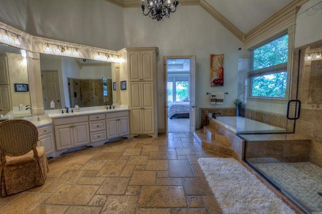 bathroom with high vaulted ceiling, tile flooring, vanity with extensive cabinet space, and an inviting chandelier