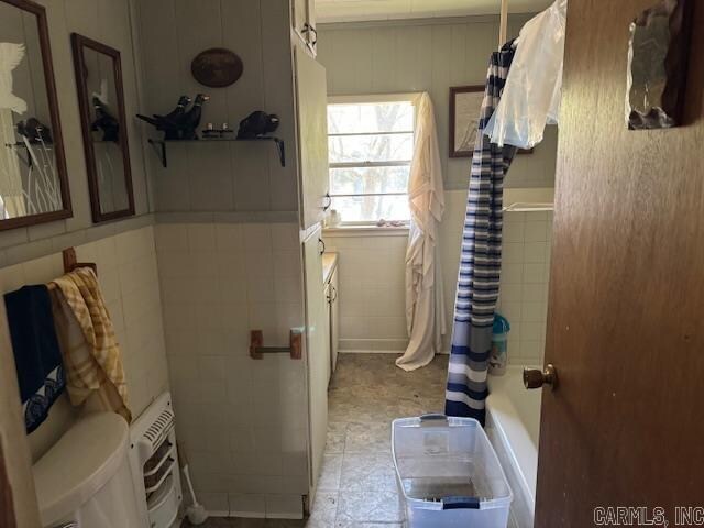 bathroom featuring tile flooring, toilet, and shower / bath combo with shower curtain