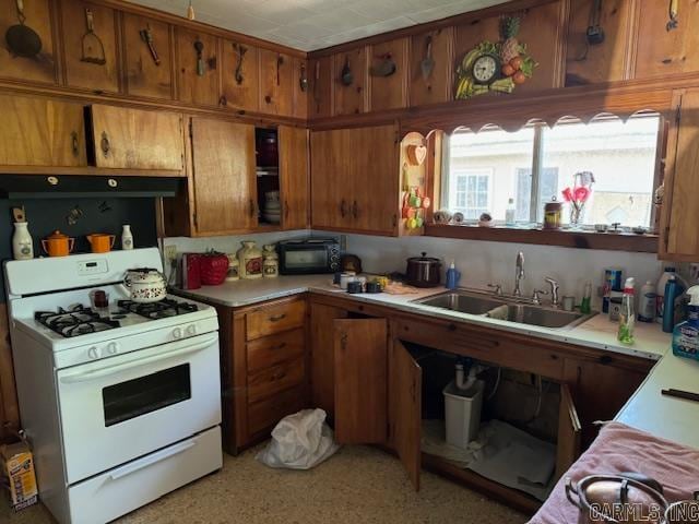 kitchen with white gas range oven and sink