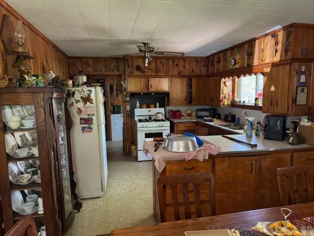 kitchen with sink, white appliances, and kitchen peninsula