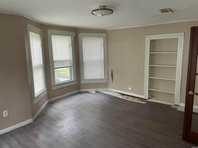 spare room with dark wood-type flooring and built in features