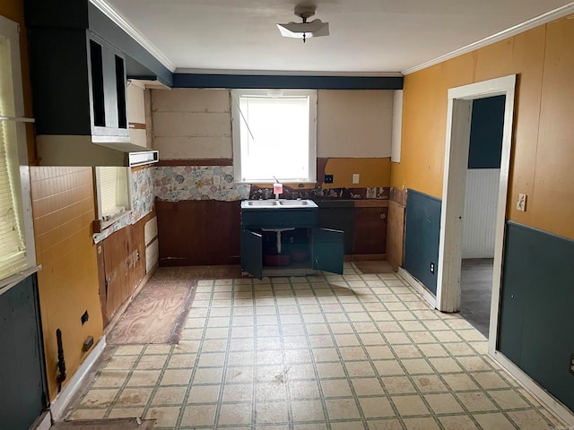 kitchen with crown molding, sink, and light tile floors