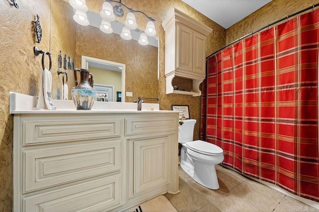 bathroom with tile flooring, vanity with extensive cabinet space, and toilet