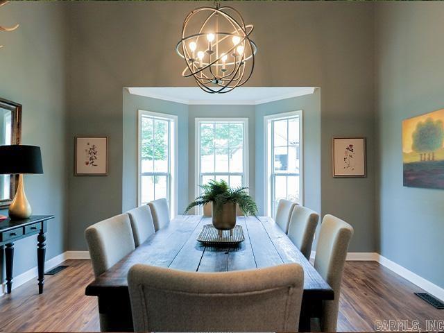 dining space featuring ornamental molding, a chandelier, and hardwood / wood-style flooring