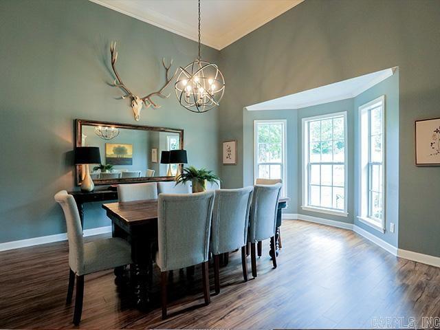 dining area featuring hardwood / wood-style floors, an inviting chandelier, and a high ceiling