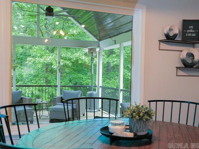 dining room with ceiling fan, hardwood / wood-style floors, and vaulted ceiling