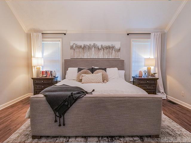 bedroom with crown molding and dark hardwood / wood-style floors