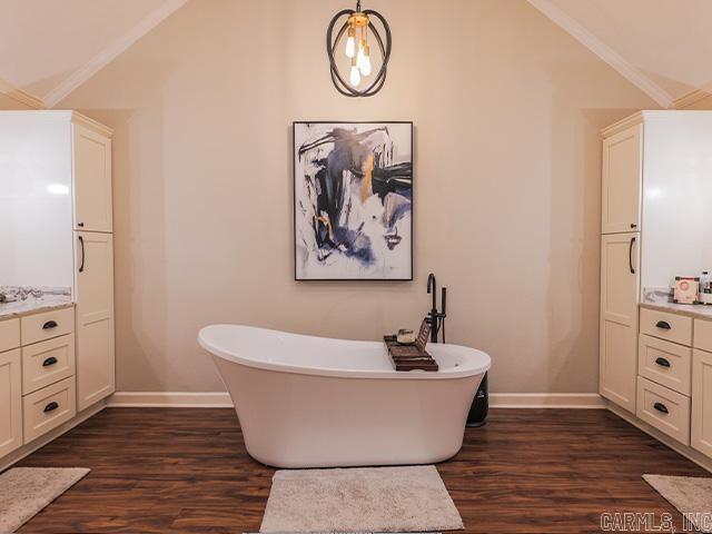 bathroom with wood-type flooring, vanity, and crown molding