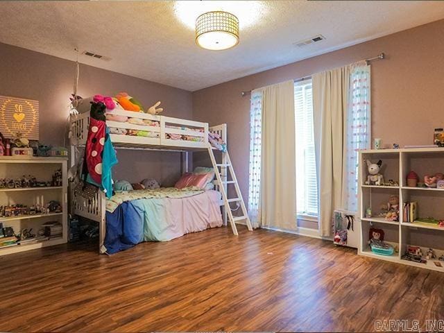 bedroom featuring hardwood / wood-style flooring and a textured ceiling