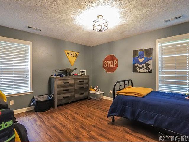 bedroom with dark wood-type flooring and a textured ceiling