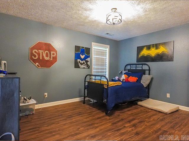 bedroom featuring hardwood / wood-style floors and a textured ceiling