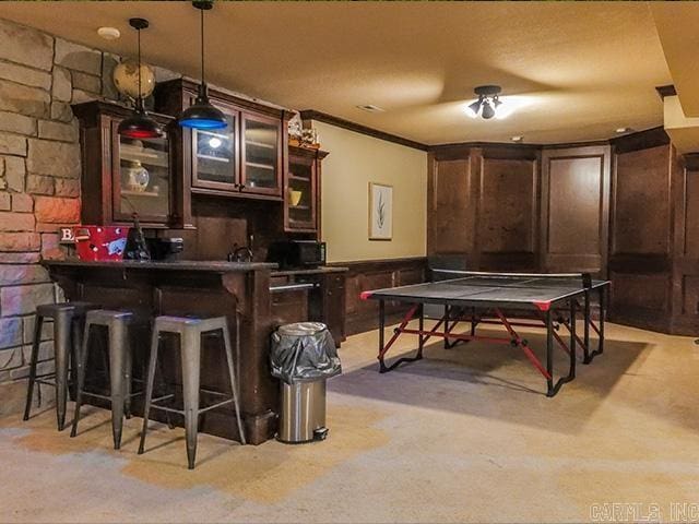 bar featuring light carpet and hanging light fixtures