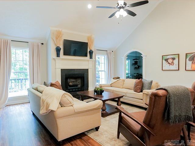 living room with hardwood / wood-style floors, ceiling fan, a healthy amount of sunlight, and high vaulted ceiling