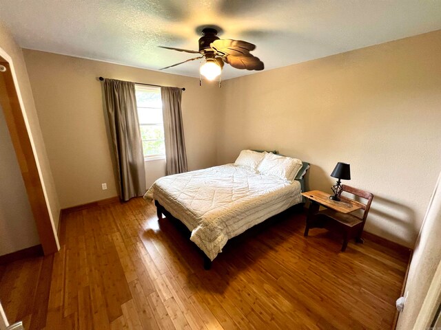 bedroom with ceiling fan and hardwood / wood-style flooring