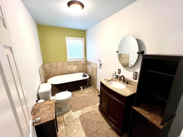 bathroom featuring tile flooring, vanity, toilet, and a washtub