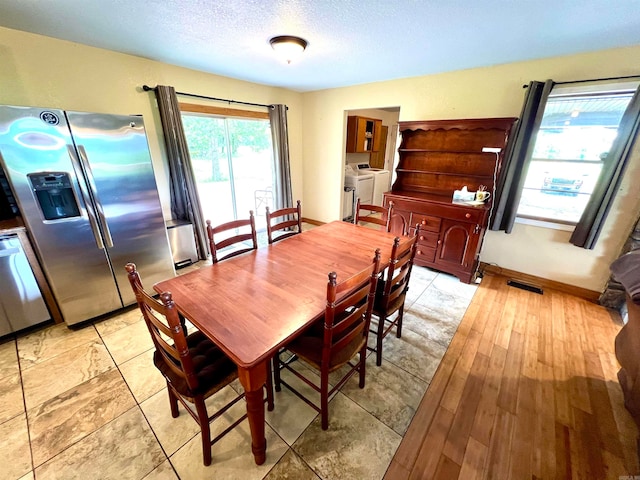 dining space with washer and clothes dryer and light tile flooring