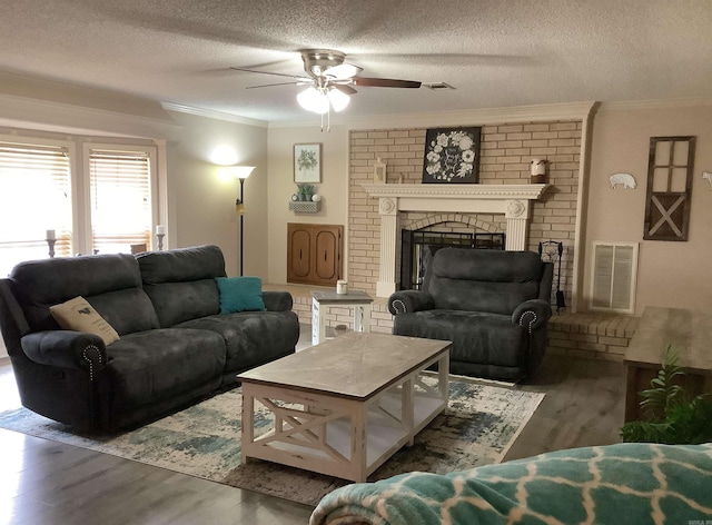 living room with ceiling fan, a fireplace, dark wood-type flooring, and a textured ceiling