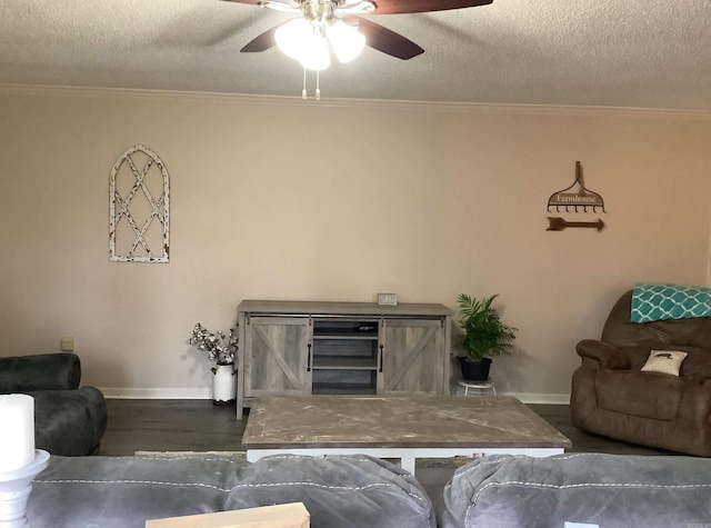 living room featuring dark hardwood / wood-style floors, ceiling fan, a textured ceiling, and ornamental molding