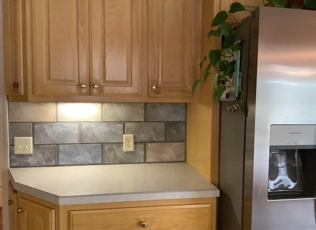 kitchen with backsplash and stainless steel fridge