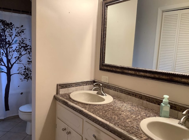 bathroom featuring toilet, oversized vanity, and tile flooring