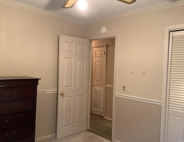 unfurnished bedroom with crown molding, a textured ceiling, ceiling fan, and carpet floors